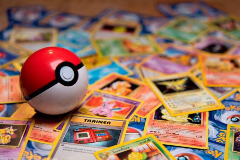 Cartas Pokémon junto a una caja Happy Meal sobre una mesa, con luz cálida y fondo neutro, imagen horizontal editorial