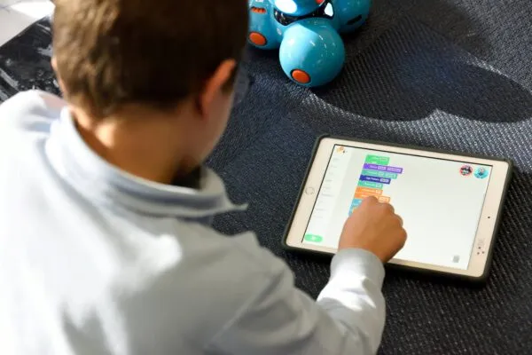 Niños interactuando con apps educativas en el celular que estimulan el aprendizaje y el desarrollo emocional