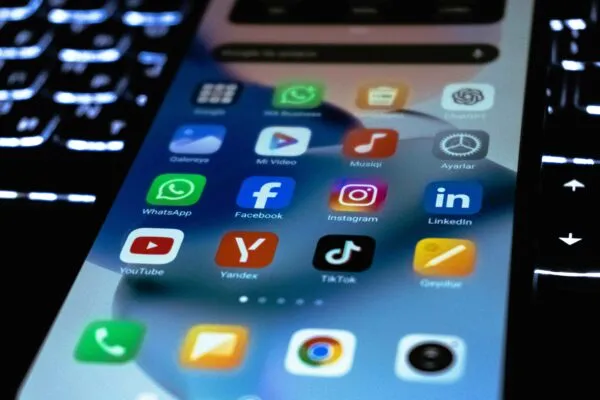 Niña con celular usando redes sociales, reflejando el impacto en su salud mental según autoridades francesas