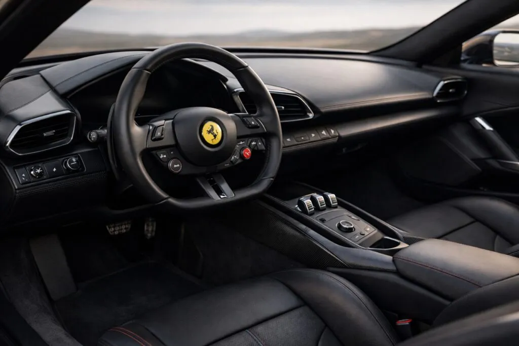 Interior Ferrari eléctrico con diseño minimalista de Jony Ive que reduce pantallas y prioriza controles físicos y experiencia de conducción