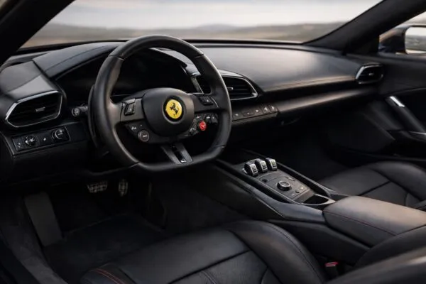 Interior Ferrari eléctrico con diseño minimalista de Jony Ive que reduce pantallas y prioriza controles físicos y experiencia de conducción