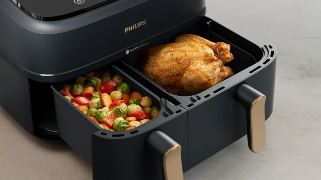 Air fryer moderna funcionando con tecnología inteligente y alimentos crujientes cocinándose con aire caliente