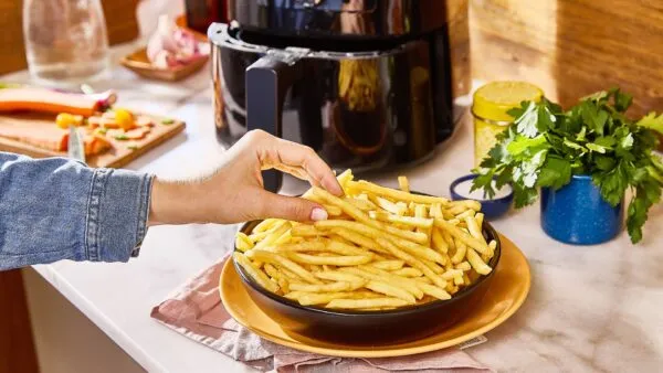 Papas McCain crujientes cocinándose en una air fryer con tecnología alimentaria avanzada