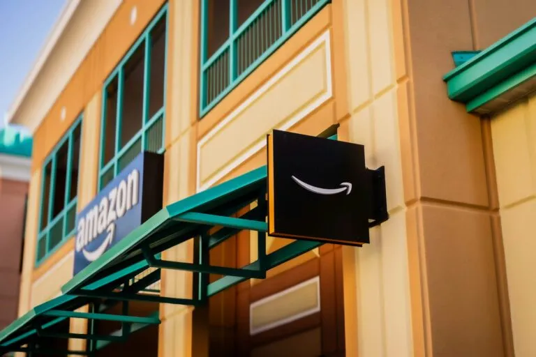 Robot de almacén con IA de Amazon operando en centro logístico europeo tras inversión de 12,000 mdd