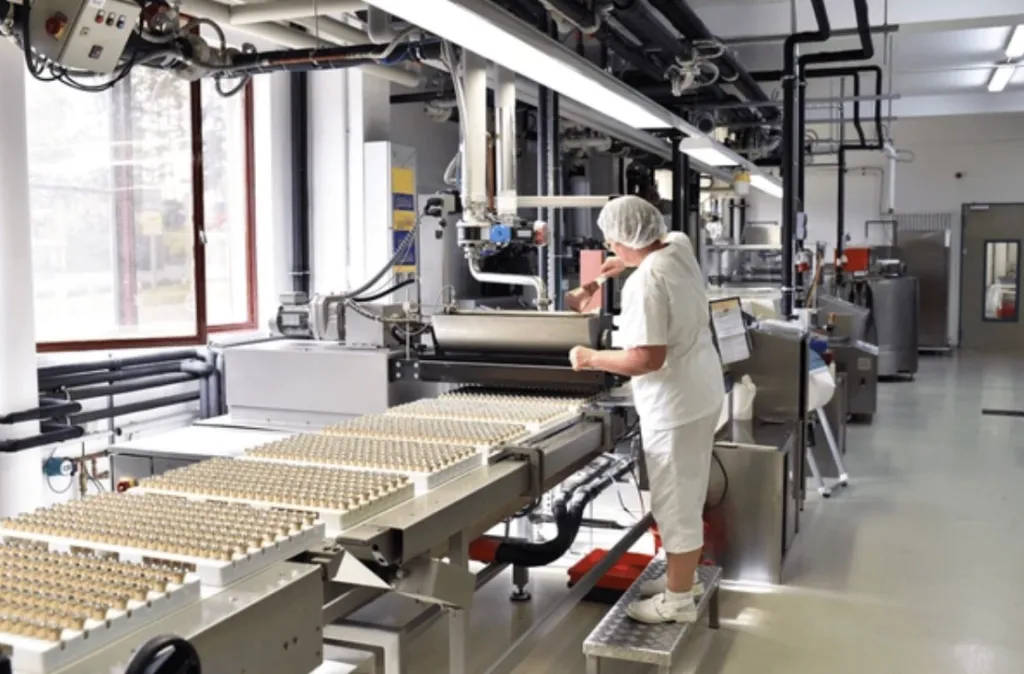 Planta de producción alimentaria equipada con robots industriales, sistemas automatizados e IA para optimizar procesos, tal como lo describen los expertos de Grupo Kosmos.