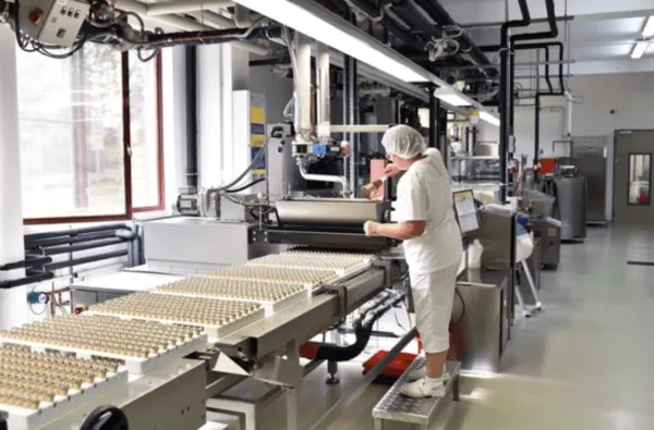 Planta de producción alimentaria equipada con robots industriales, sistemas automatizados e IA para optimizar procesos, tal como lo describen los expertos de Grupo Kosmos.