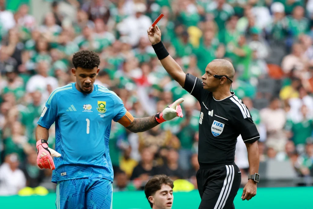 Árbitro de fútbol equipado con tecnología avanzada, reloj inteligente, auriculares y sistemas digitales durante un partido internacional