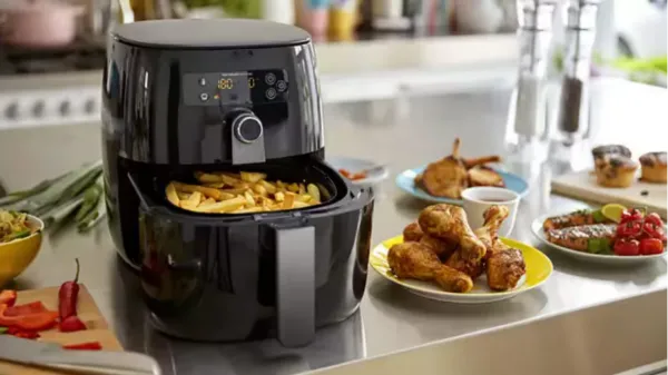 Air fryer moderna junto a un horno tradicional mostrando la evolución de la tecnología culinaria