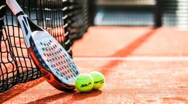 Jugador de pádel utilizando una pala de última generación en una cancha moderna con tecnología avanzada