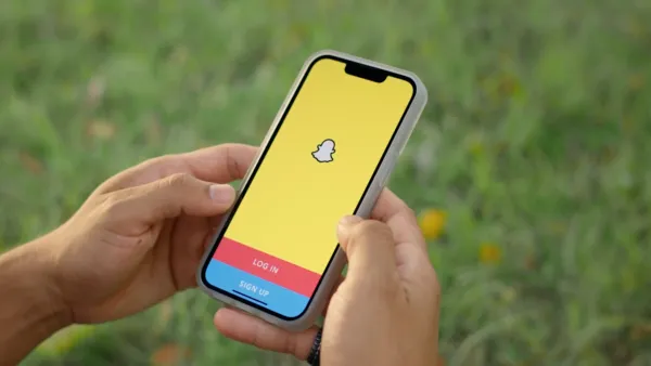 Usuario utilizando Snapchat con filtros de realidad aumentada y contenido efímero en un smartphone.``