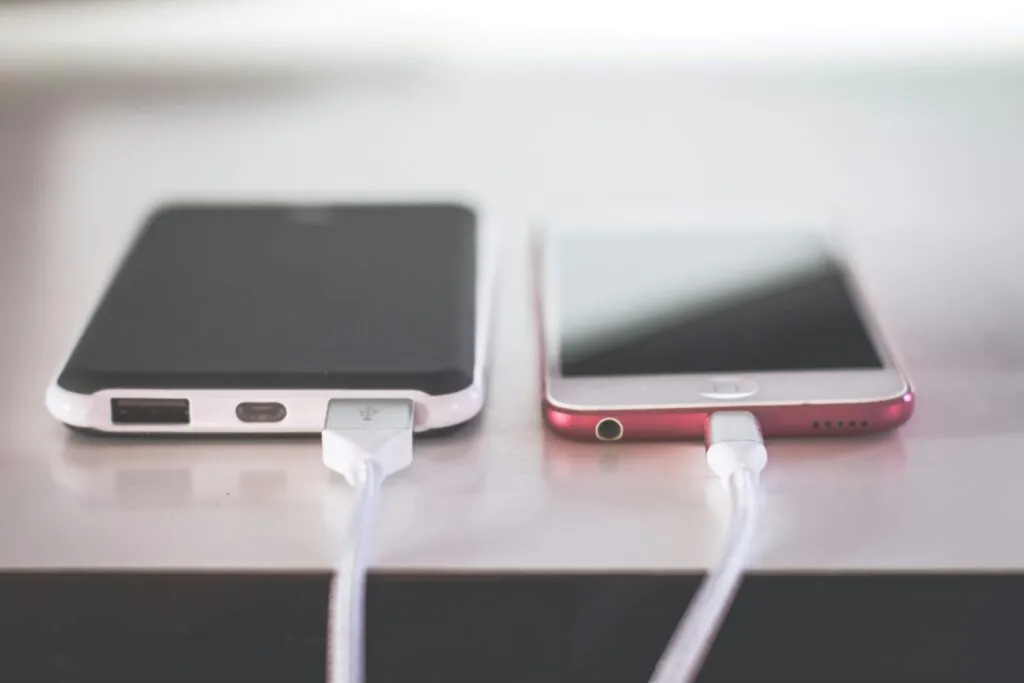 Persona cargando un smartphone correctamente para cuidar la batería y prolongar la vida útil del dispositivo.