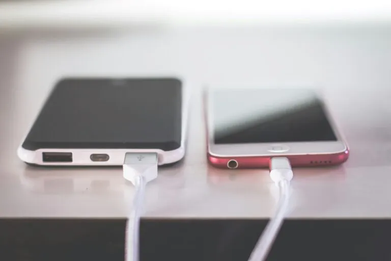 Persona cargando un smartphone correctamente para cuidar la batería y prolongar la vida útil del dispositivo.