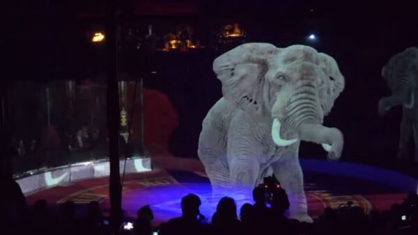 Una carpa de circo futurista con un elefante holográfico proyectado sobre la pista.
