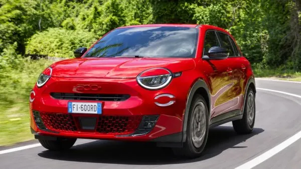 Auto eléctrico compacto circulando por una ciudad y representando la autonomía urbana anunciada para el Fiat 600e.